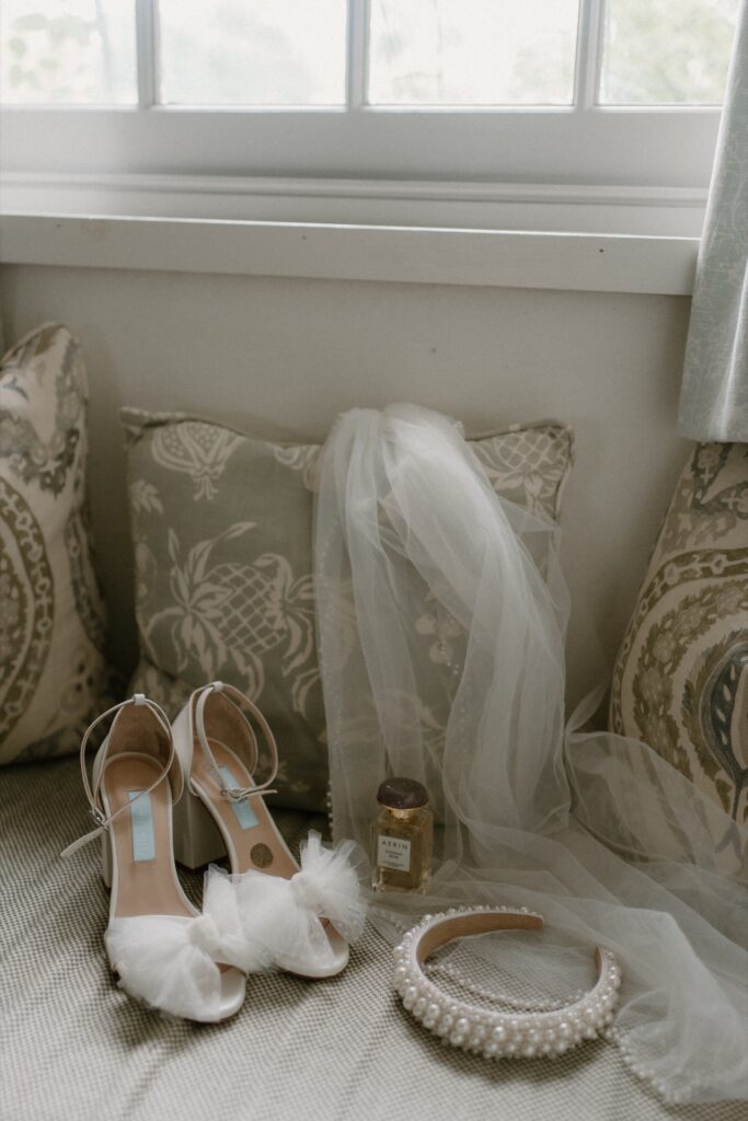 Bridal details including Charlotte Mills wedding shoes with tulle bow, a pearl embellished headband, veil and Jo Malone perfume.