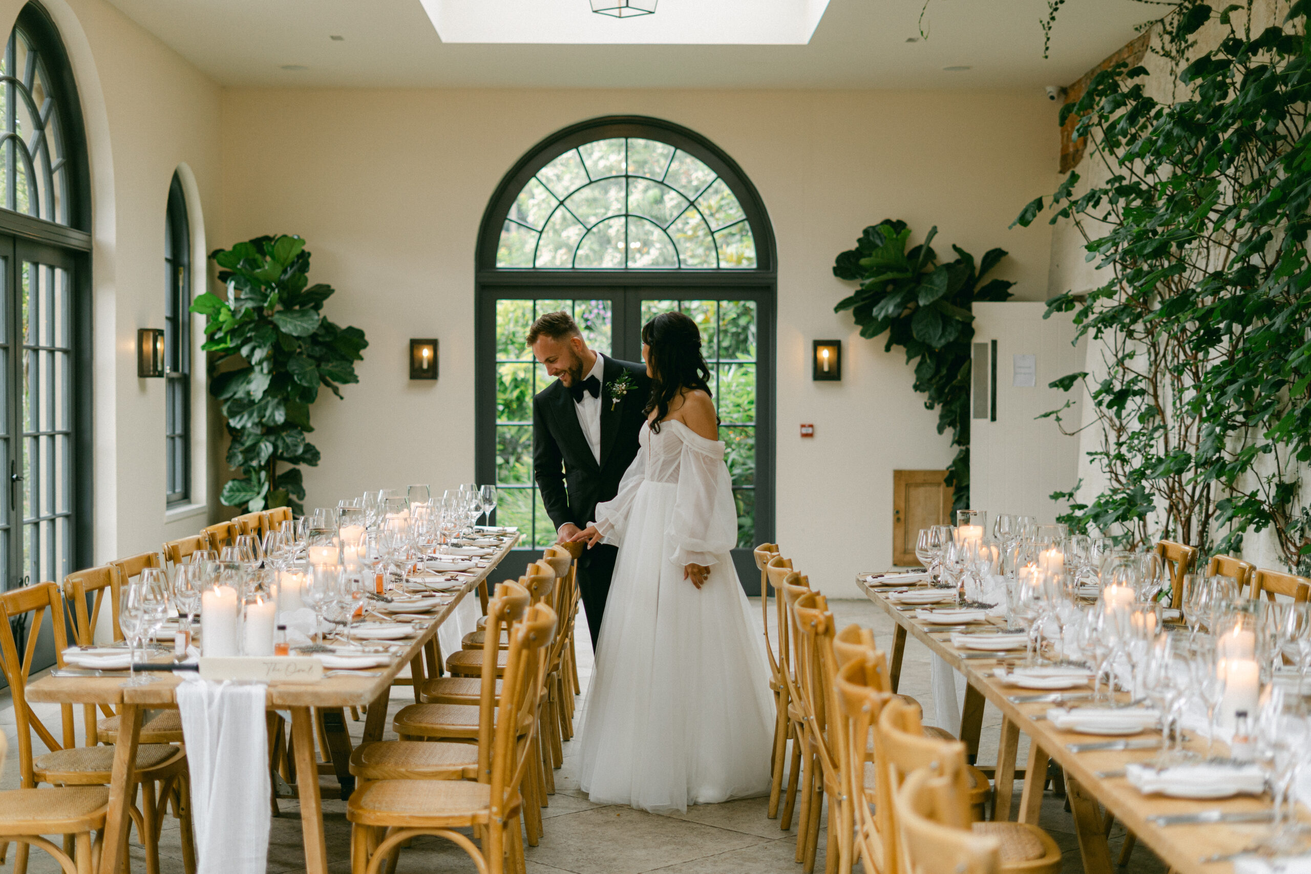 A bride & groom look at the details of their Fig House wedding reception at Middleton Lodge